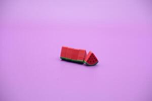 Mini watermelon toy isolated on purple background. purple background with watermelon toys. photo