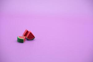 Mini watermelon toy isolated on purple background. purple background with watermelon toys. photo