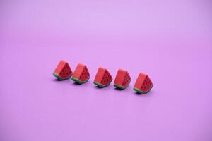 Mini watermelon toy isolated on purple background. purple background with watermelon toys. photo