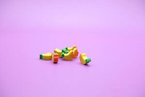 Mini banana toy isolated on purple background. purple background with banana toys. photo