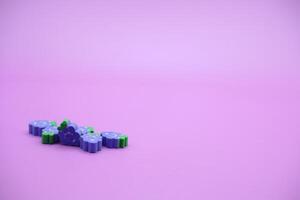 purple background with grape toys. Grape-shaped eraser isolated on purple background. photo