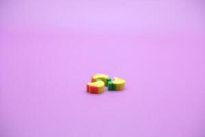 Mini banana toy isolated on purple background. purple background with banana toys. photo