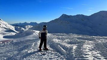 a person on skis standing on a mountain photo