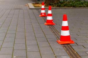 red and white road cones on a footpath photo