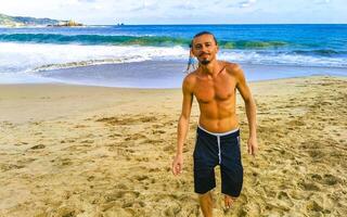 Handsome male tourist traveler at tropical beach in Mazunte Mexico. photo