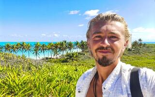 Handsome male tourist tropical natural beach panorama Contoy island Mexico. photo