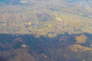 Flying airplane over Mexico Clouds Sky Volcanoes Mountains City desert. photo