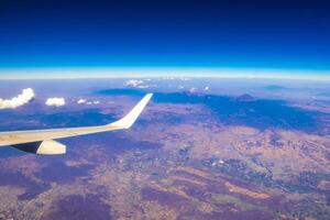 Flying airplane over Mexico Clouds Sky Volcanoes Mountains City desert. photo