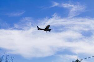 Watsonville, CA, 2011 - Small Red And White Prop Plane In Blue Sky With Clouds photo