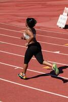 Young plump black woman running on track photo