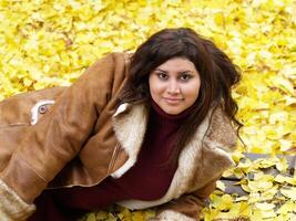 young plus-size model with yellow fall leaves and jacket photo