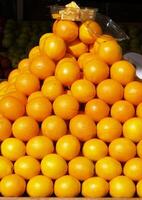Pyramid of oranges in store front display photo