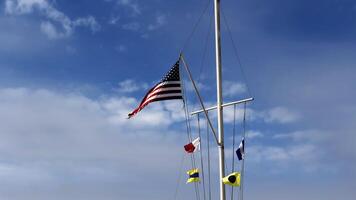 United States Flag And Naval Signal Flags Flying On Nautical Flagpole photo