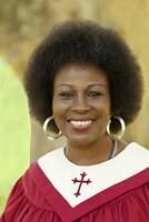 Middle-Aged Woman Smiling Outdoors Red Church Robe photo