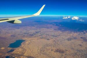 Flying airplane over Mexico Clouds Sky Volcanoes Mountains City desert. photo