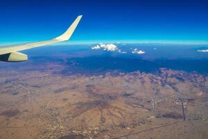 Flying airplane over Mexico Clouds Sky Volcanoes Mountains City desert. photo