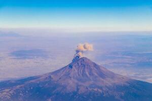 Flying airplane over Mexico Clouds Sky Volcanoes Mountains City desert. photo