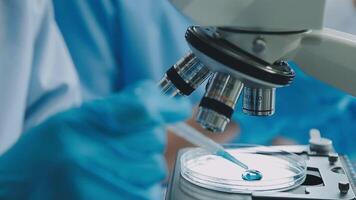 Health care researchers working in life science laboratory. Young female research scientist and senior male supervisor preparing and analyzing microscope slides in research lab. video