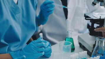 Health care researchers working in life science laboratory. Young female research scientist and senior male supervisor preparing and analyzing microscope slides in research lab. video