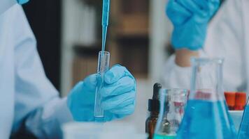 Health care researchers working in life science laboratory. Young female research scientist and senior male supervisor preparing and analyzing microscope slides in research lab. video