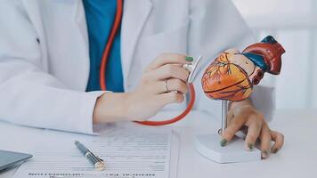 Anatomical model of the human heart in doctor's hands. Cardiological consultation, treatment of heart diseases. Medical concept video