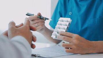 Female pharmacist holding medicine bottle giving advice to customer in chemist shop or pharmacy video