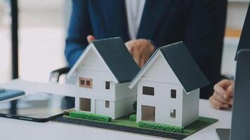 verklig egendom ombud och kund diskuterar för kontrakt till köpa, skaffa sig försäkring eller lån verklig egendom eller fast egendom. video