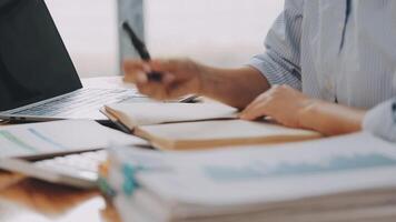 Businesswoman using phone, taking notes at office desk video