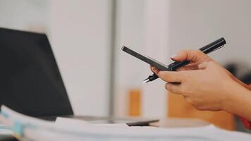 Businesswoman using phone, taking notes at office desk video