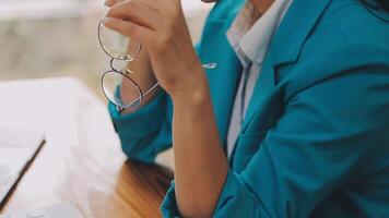 Businesswoman using phone, taking notes at office desk video