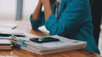 Businesswoman using phone, taking notes at office desk video