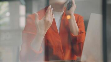 Businesswoman using phone, taking notes at office desk video