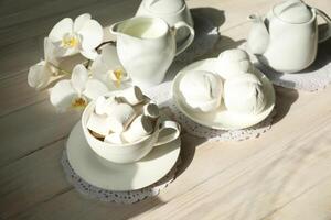 Spring breakfast with marshmallow, coffee and milk. Flatlay with food and flower in white color photo