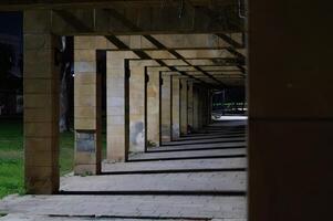A long, empty hallway with a few pillars photo