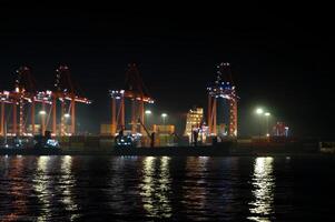 A large ship is docked at a port at night photo