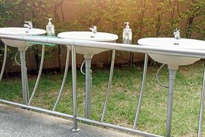 Sink for washing face, installed in 3 sets next to each other. photo