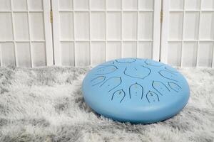blue steel tongue drum on a fluffy rug photo