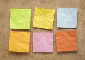 set of colorful blank reminder notes on textured bark paper photo