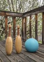 pair of Indian exercise clubs and a heavy medicine ball on a wooden deck - functional fitness concept photo