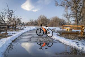 mountain bike on Poudre River Trail near Greeley in Colorado, winter scenery with puddle reflection photo