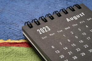 agosto 2023 - de cerca de un pequeño escritorio calendario en contra resumen papel paisaje, hora y negocio concepto foto