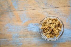 sun-dried white mulberry berries in a small glass bowl against grunge wood with a copy space photo