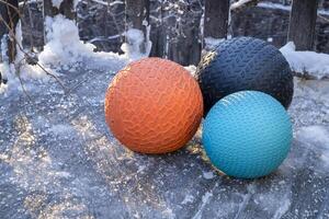 heavy slam balls filled with sand on an icy backyard deck, exercise and functional fitness concept photo