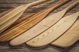 set of wooden canoe paddles against rustic wood photo