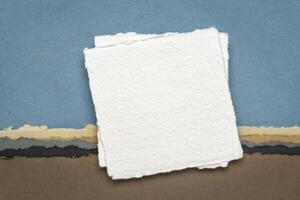 small sheet of blank white Khadi rag paper from India against abstract landscape in earth pastel tones photo