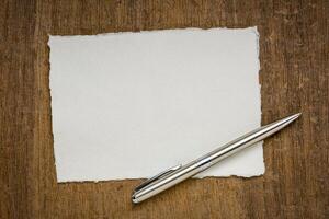 small sheet of blank white Khadi rag paper from South India against textured bark paper photo