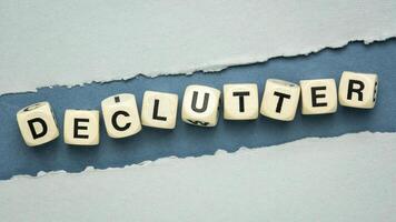 declutter word in wooden dice cubes on a handmade textured paper, simplicity, minimalism and lifestyle concept photo