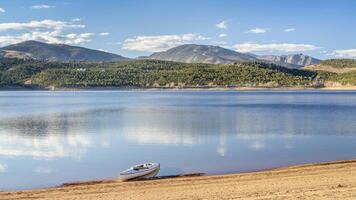 expedition canoe on a sandy beach of Carter Lake in northern Colorado, warm winter afternoon photo