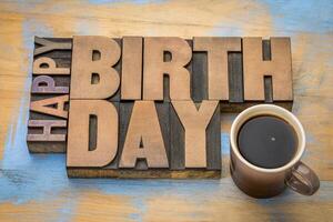 Happy Birthday greeting card - word abstract in vintage letterpress wood type blocks with a cup of coffee photo