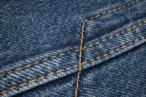 closeup of stitching on a blue denim jacket photo